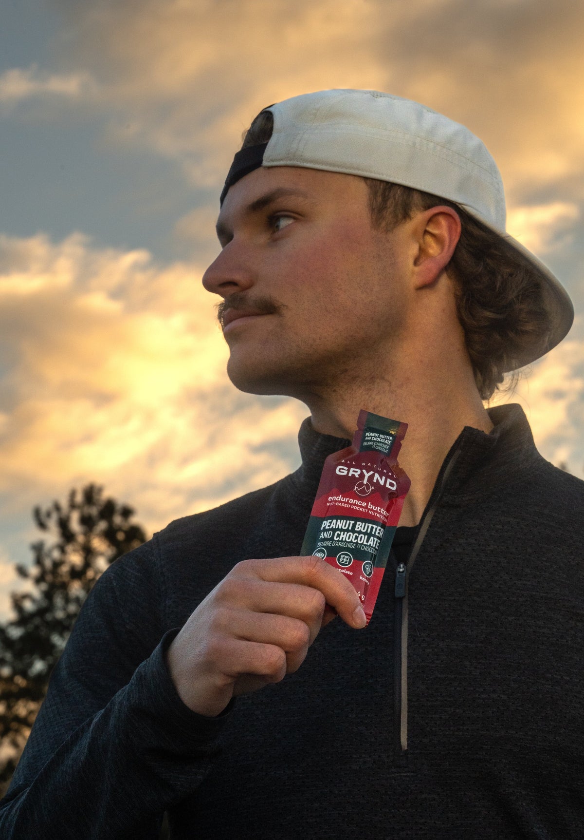 Man holding Grynd Endurance Butter during golden hour while training outdoors